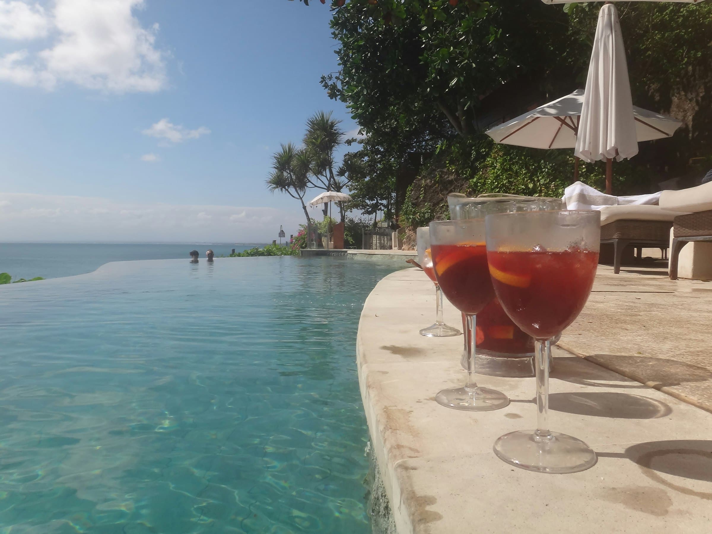 Two cold drinks on the edge of a pool overlooking the sea (placeholder photo)